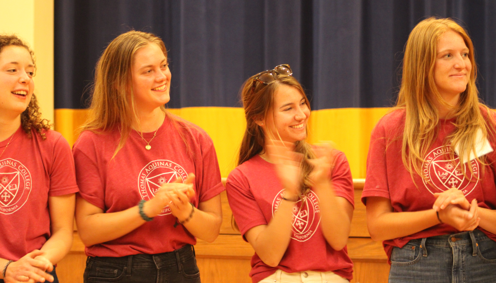 A row of red-clad prefects applaud