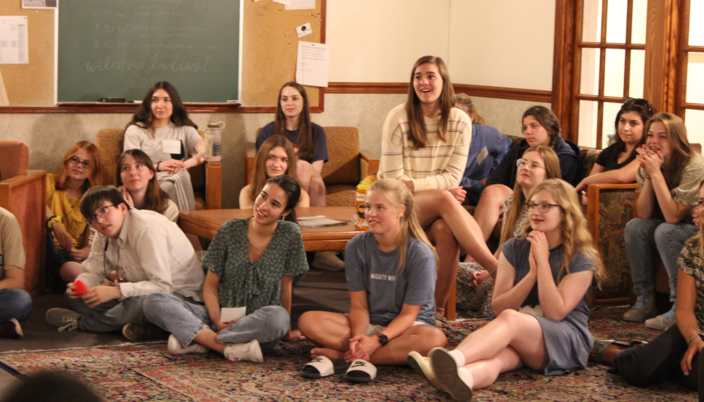 Women's dorm prefect address: students on couches and armchairs around a corner table
