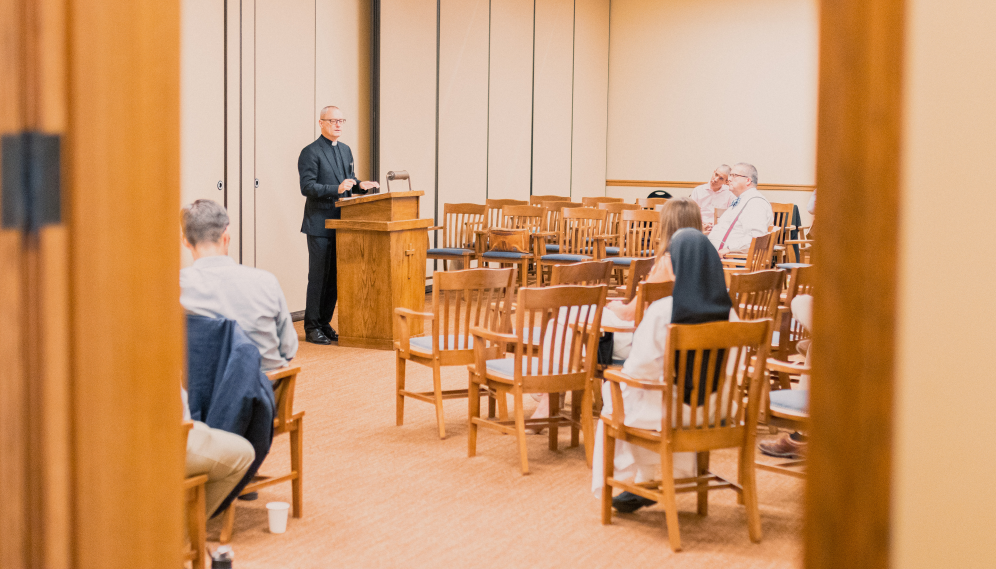 A priest gives a lecture in the Dillon Seminar Room