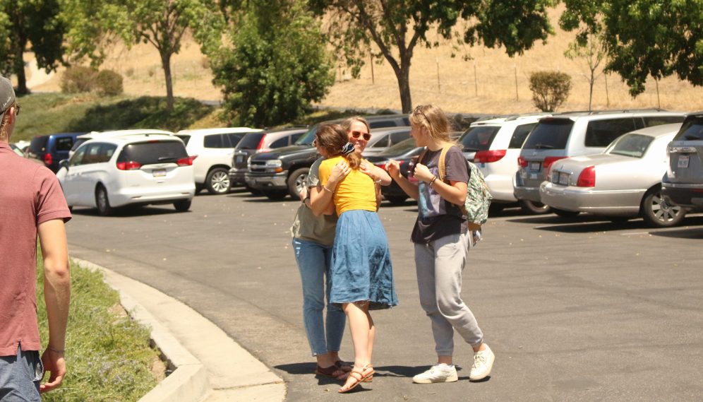 A freshman hugs her family members