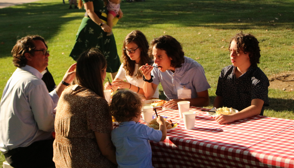 Students eating at one end of one of the picnic tables