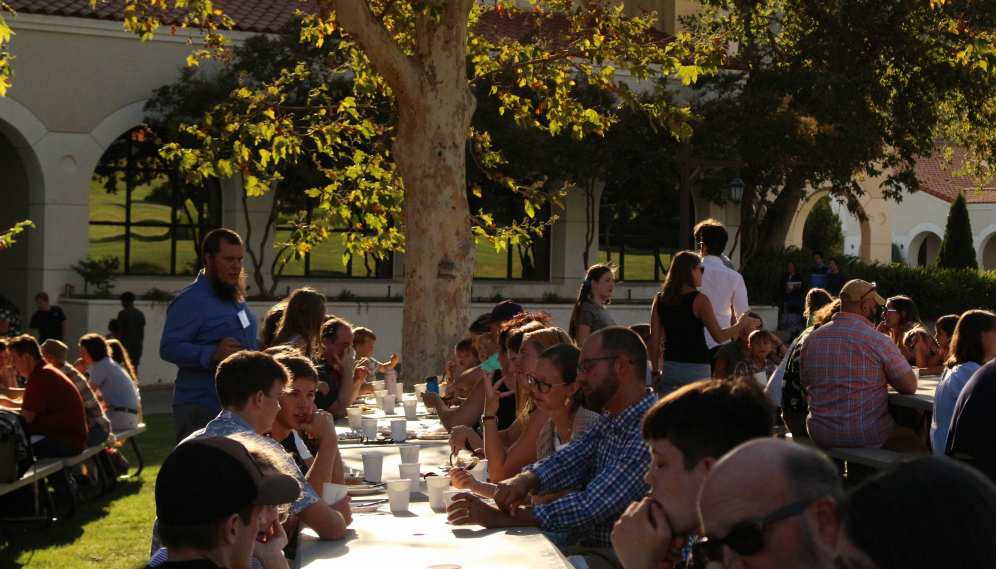 View down a long table filled with students and their families