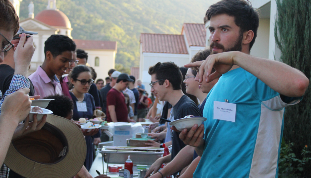 A line of freshmen receiving ice cream at the serving table