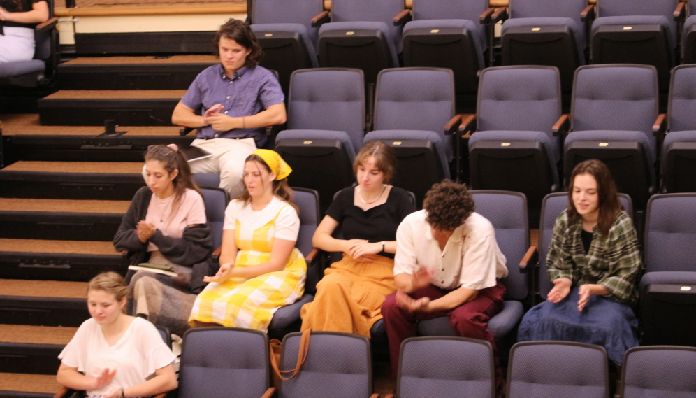 A group of students in the benches applaud