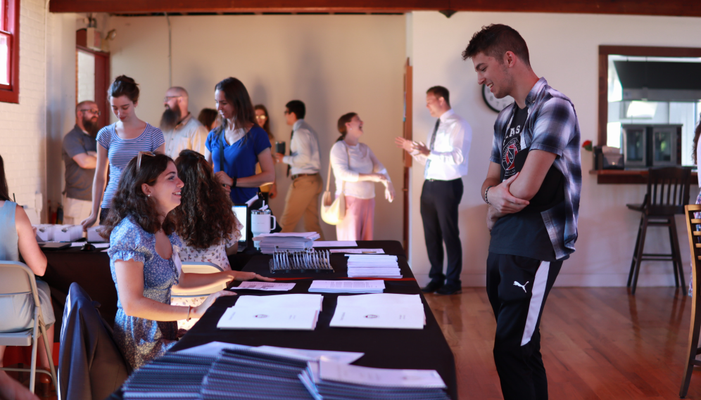 A student receives their handbook