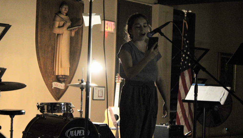 A student reads something from her phone at the mic