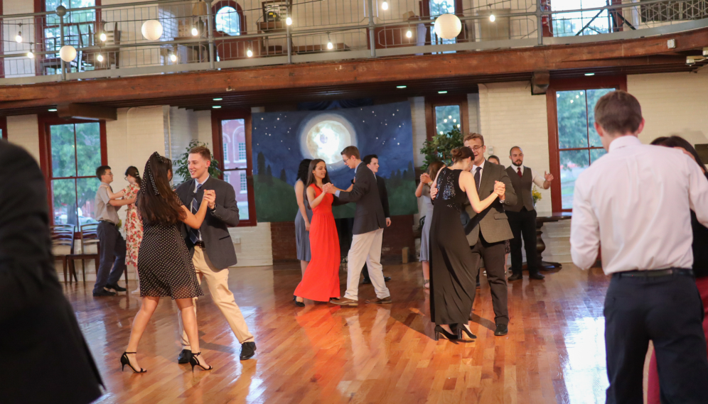 Student couples dancing afront the "moonlight night" mural