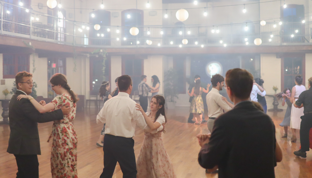 Three student pairs dance in the foreground