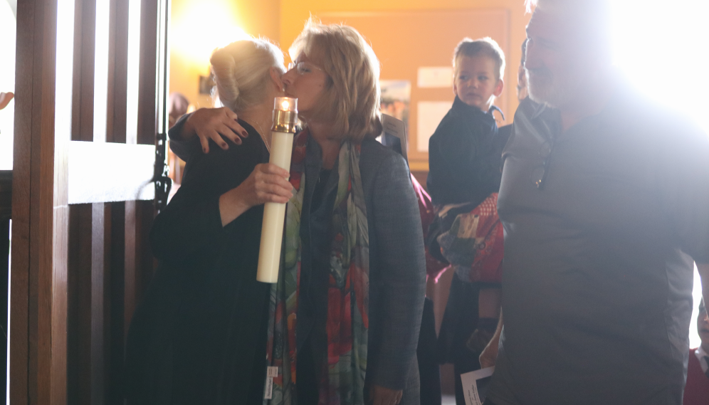 Two longtime friends of Nurse Nancy's embrace at the Chapel entrance