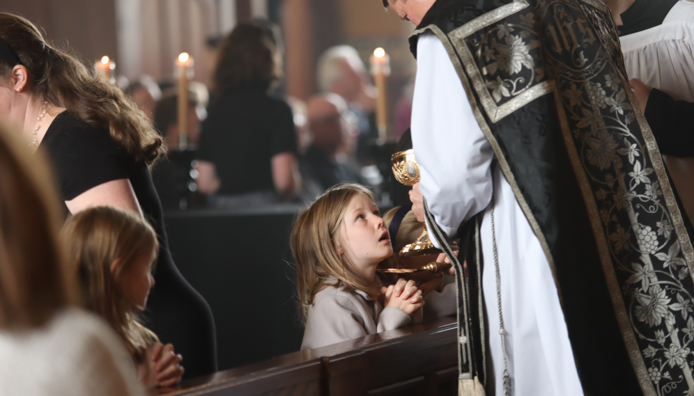 The faithful receive Communion at the rail