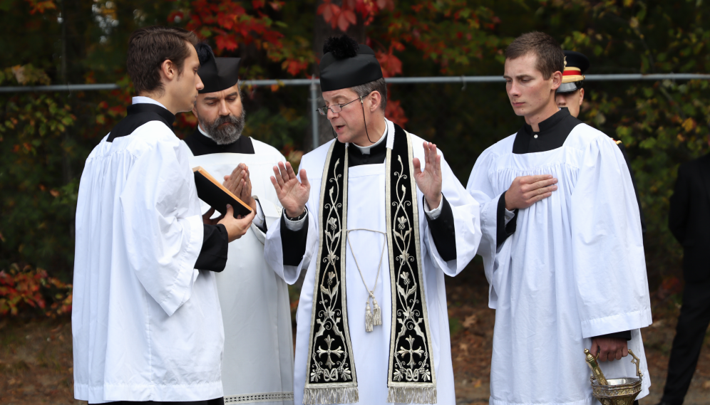 Another view of Fr. Markey blessing the casket