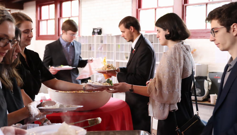 Funeral attendees line up to collect food