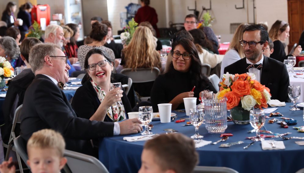 At one table, attendees laugh and chat