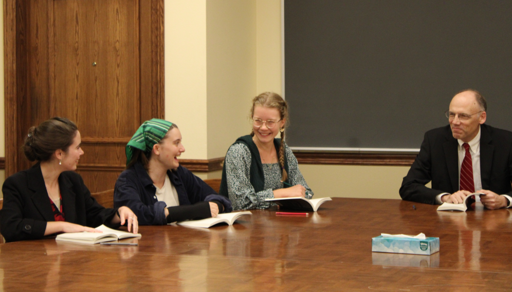 A student makes an amusing point, and the tutor and two others chuckle