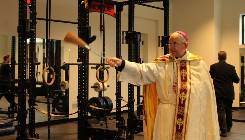 The Archbishop blesses the gym equipment