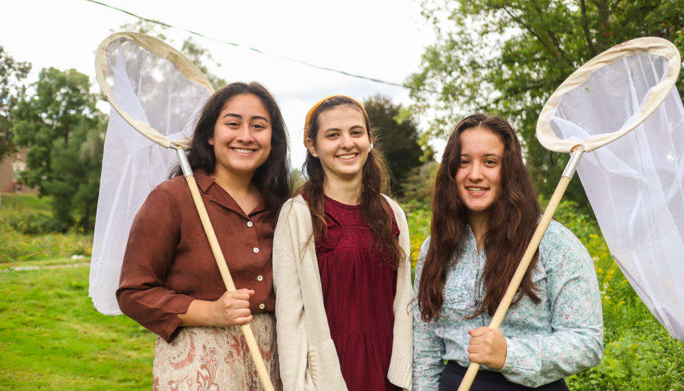 Three pose for a photo, nets in hand