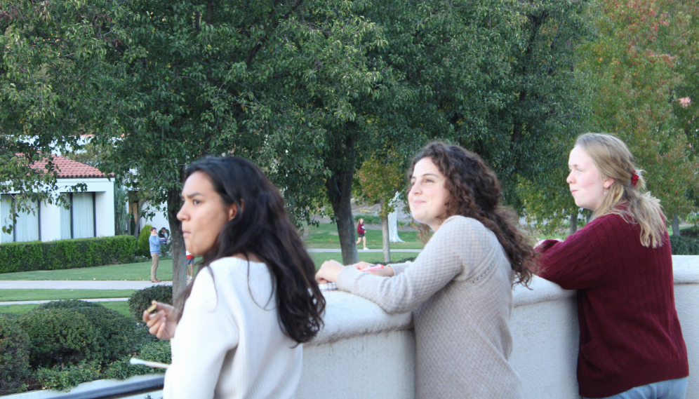 Three looking into the distance over the balcony edge