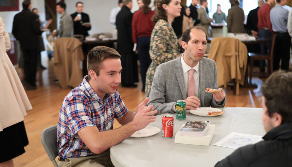 Students chat over pizza after the seminar