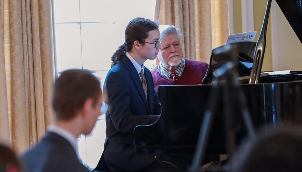 Another student plays while Mr. Grimm turns the pages