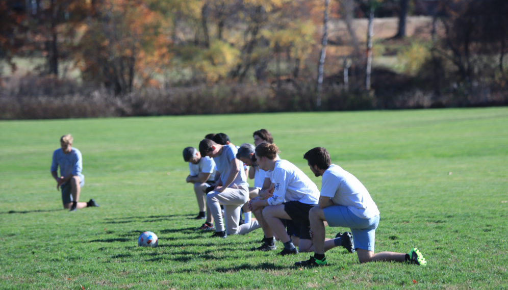 Players kneel in prayer before the game
