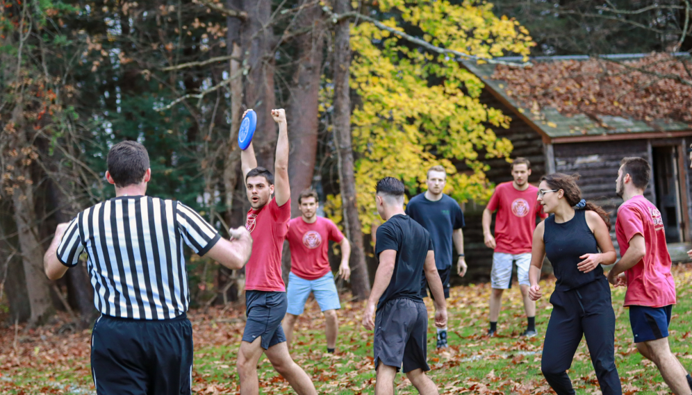 A student cheers, arms upraised and Frisbee in hand