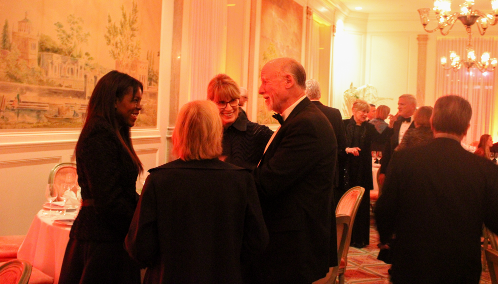 Groups converse in the dining room before sitting down