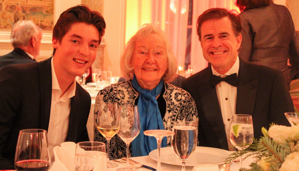 Three at a table pose for a photo