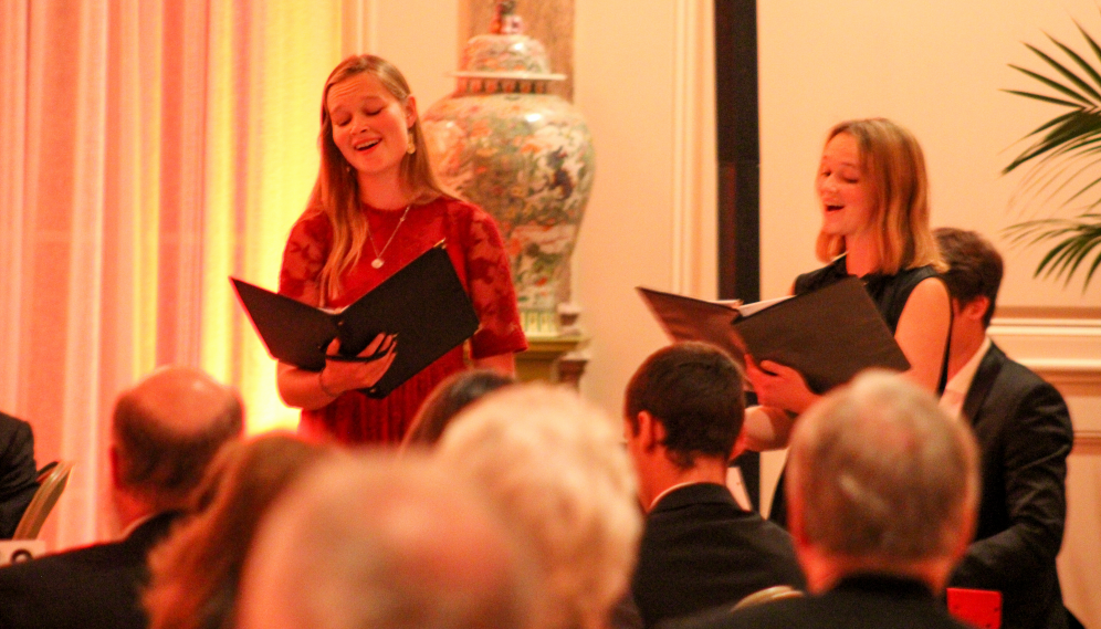 Two singers and a pianist perform for the assembled attendees