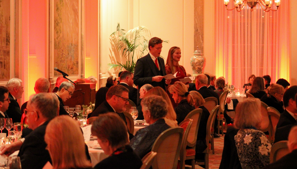 Long shot of two singers performing for the tables