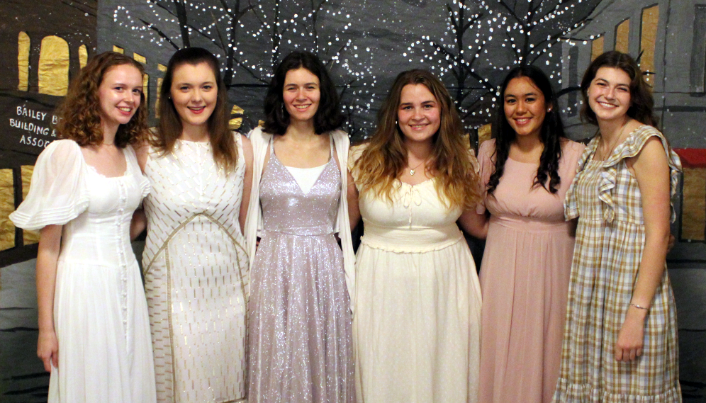 Six pose for a photo in their Christmas dresses