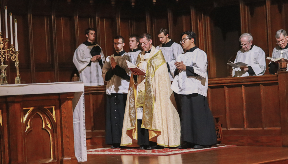 Fr. Markey reads, flanked by altar boys