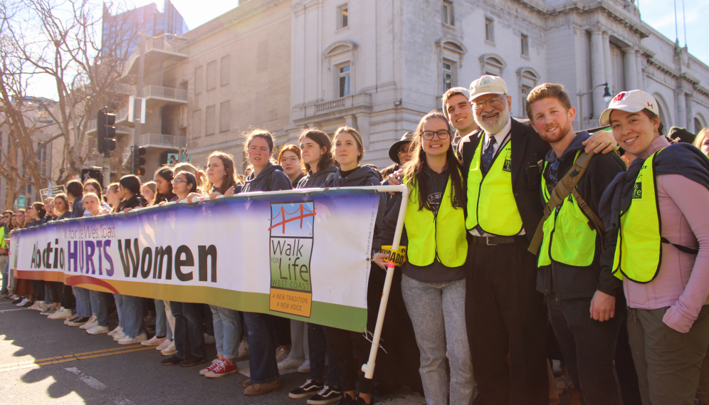 TAC students at the head of a banner reading "Abortion HURTS Women"