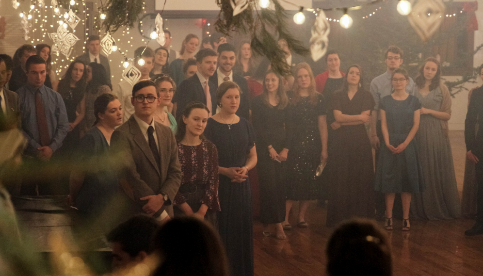 Students gather near the piano for caroling