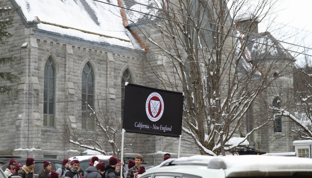 Banner aloft, students line up outside the church
