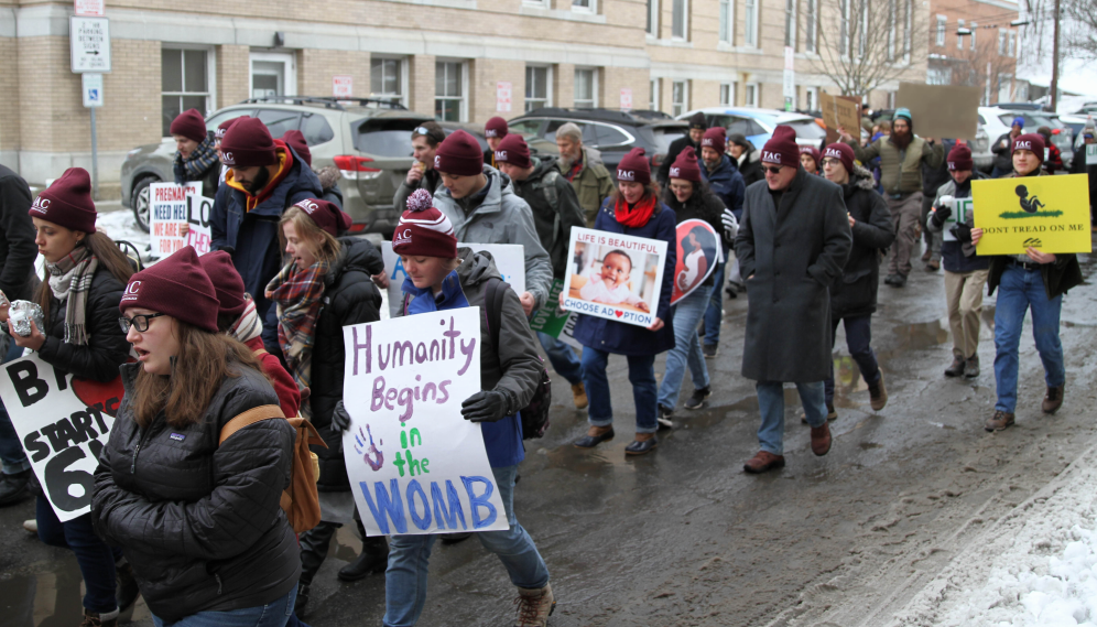 Students march, signs in hand