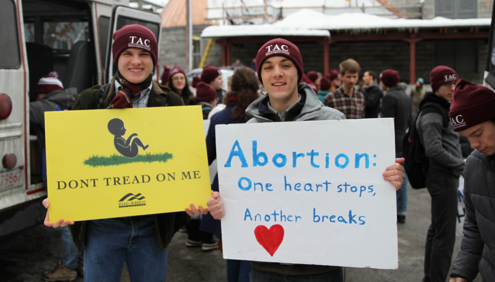 Two pose with their signs