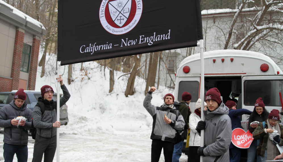 A student makes the "upraised fist" symbol as two others hold the banner