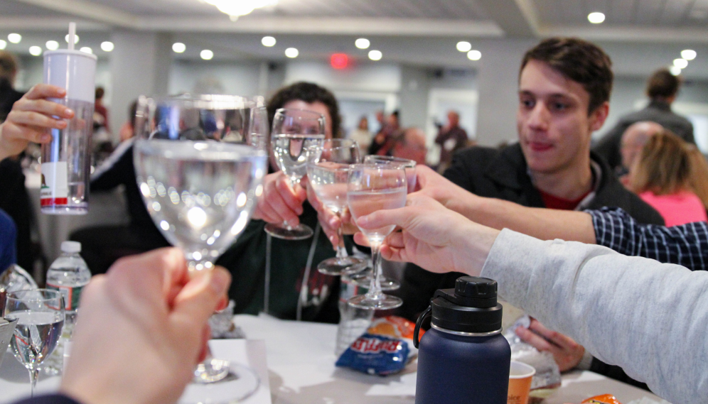 Students "cheers" one another with fancy glasses filled with water