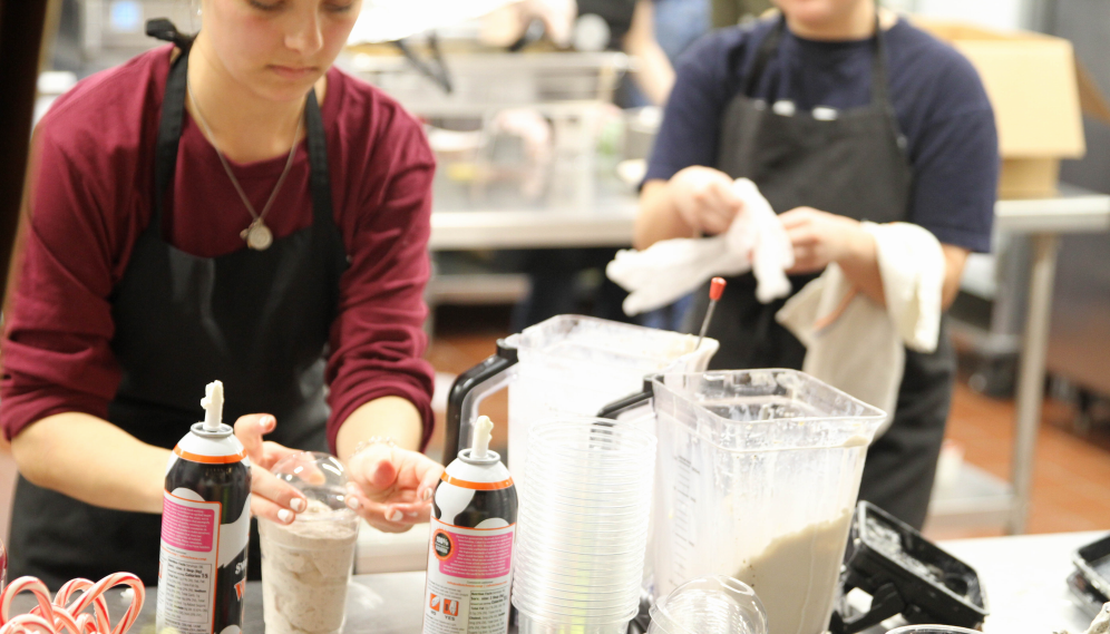 A coffee-shop worker prepares milkshakes