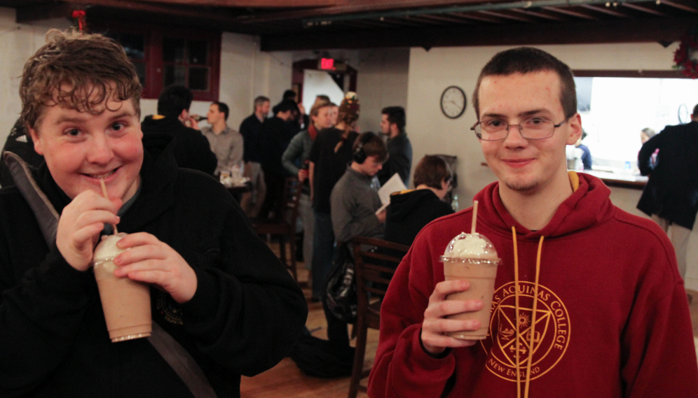 Two pose for a photo, milkshakes in hand