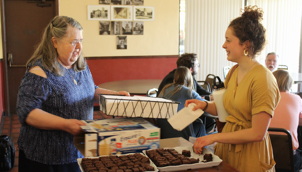 A smiling student selects a brownie
