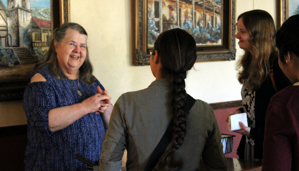 Mrs. O'Flynn chats with students, smiling happily