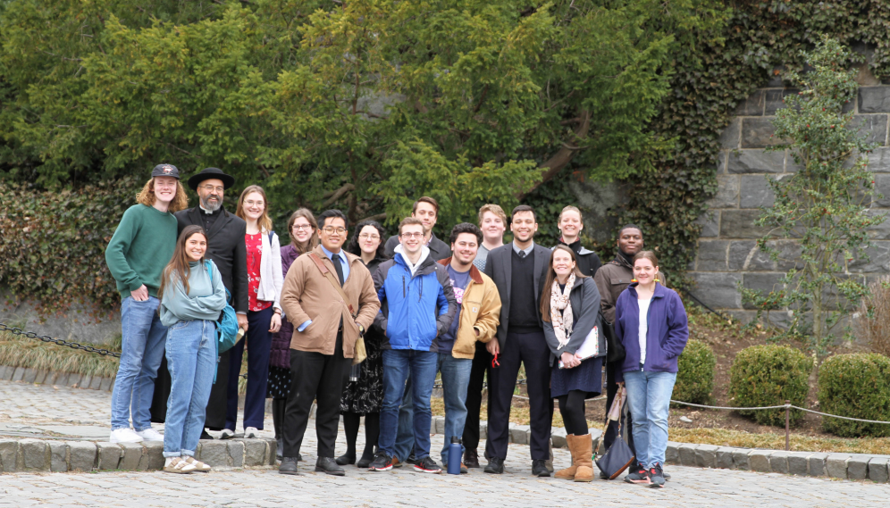 The trip-takers pose for a photo outside afront a stone wall.