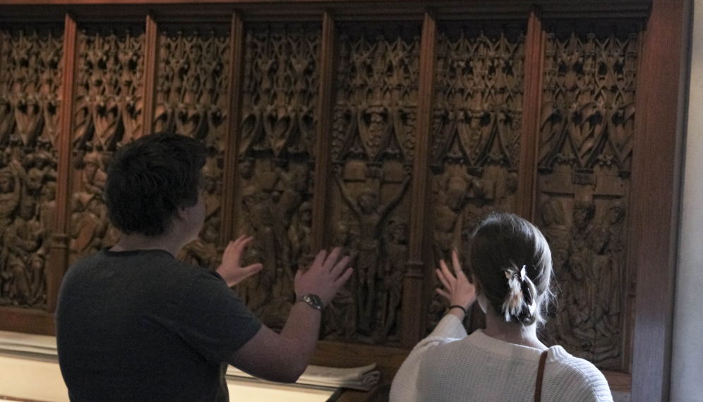 Two feel a series of wood-panel carvings depicting the Stations of the Cross