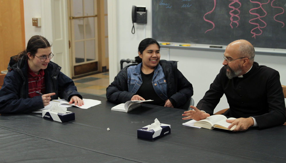 Fr. Viego discusses the text with 2 other students
