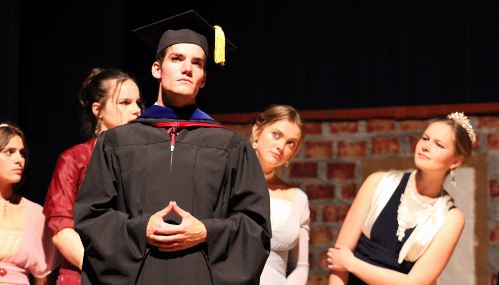 The ladies admire someone in academic regalia