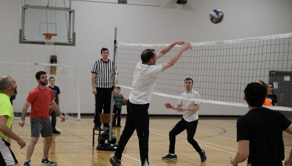 Fr. Markey sends the ball over the net