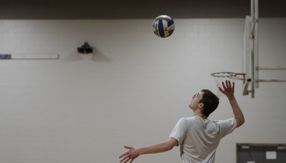 A student serves the ball overhand