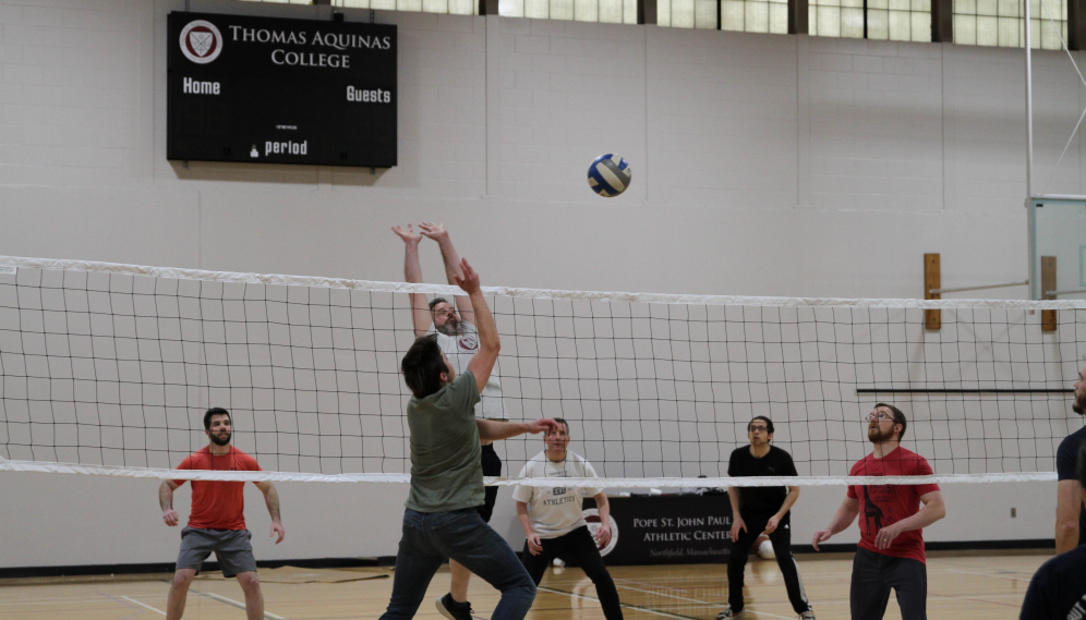 Tutors attempt to block the ball as the students send it across the net