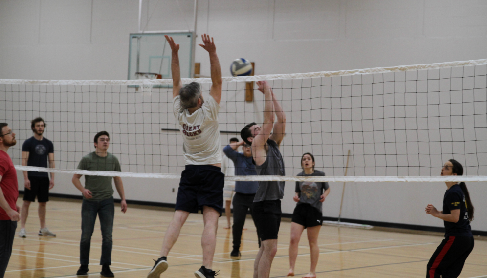 A tutor blocks as a student prepares to send the ball over